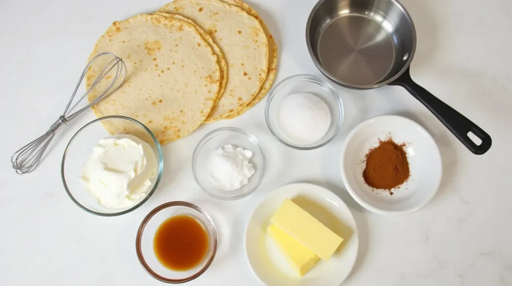 Ingredients for Xango dessert arranged on a countertop, including cream cheese, sugar, tortillas, cinnamon, butter, and caramel sauce, alongside a whisk and frying pan.
